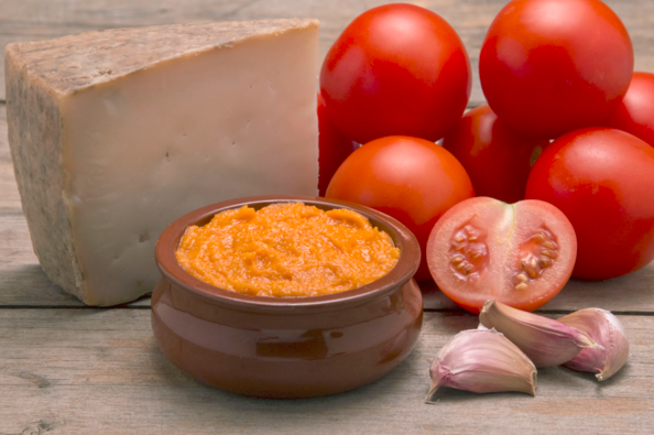 image of hard cheese and cheest dip with tomatos and garlic cloves